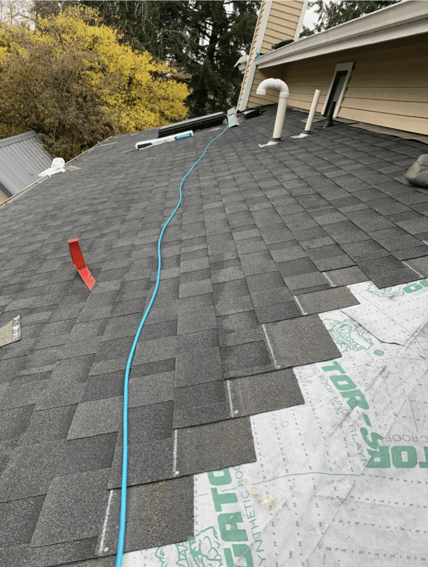 New composition shingle roof being installed over synthetic underlayment on a Seattle-area home