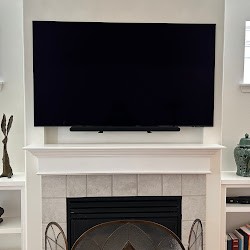 Remodeled living room fireplace with tile surround and a wall-mounted television above the mantel