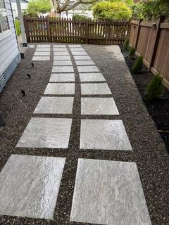 New concrete paver walkway set in gravel alongside a cedar fence in a Bothell backyard
